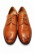 Pair of brown leather shoes with crocodile texture on a white background