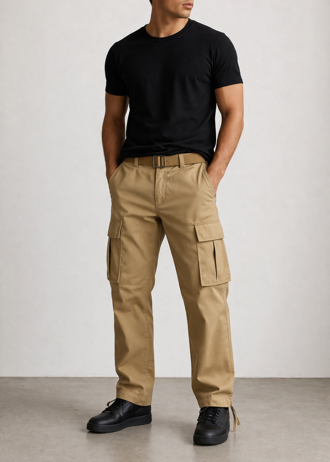 Person wearing beige cargo pants and a black t-shirt against a white background